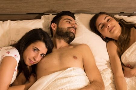 pareja liberal con otra mujer en la cama